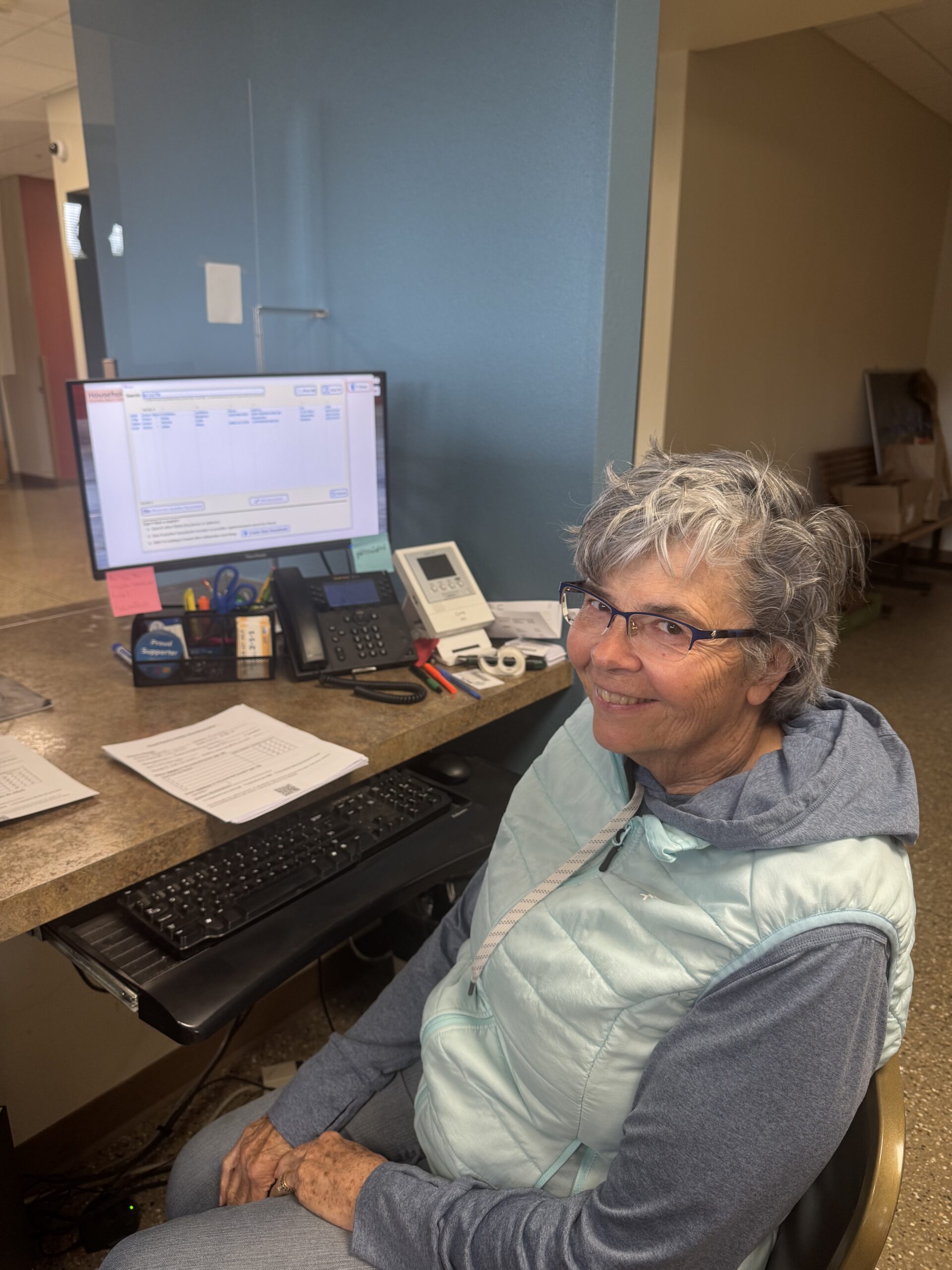smiling volunteer at svdp at a desk