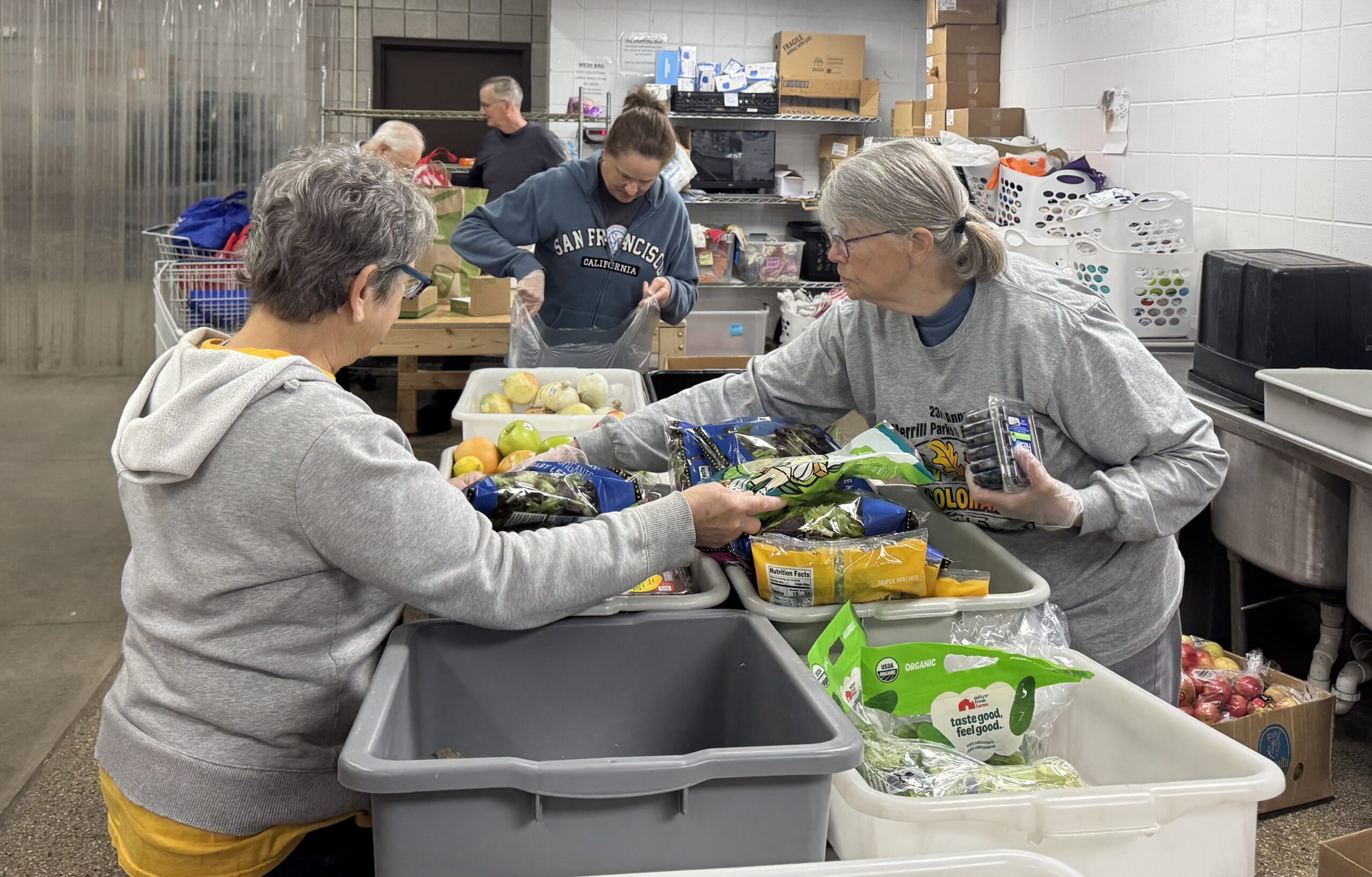 two volunteers at svdp helping sort items