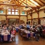 large photo of the crowd seated at luncheon tables